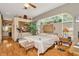 Spacious bedroom with hardwood floors, large window, and comfortable seating area at 14680 Linden Dr, Spring Hill, FL 34609