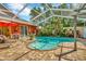 Backyard with a screened-in pool, patio, and lush landscaping at 14680 Linden Dr, Spring Hill, FL 34609