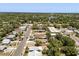 An aerial view shows a residential neighborhood with tree-lined streets and a glimpse of a lake in the distance at 1465 Pierce St, Clearwater, FL 33755
