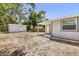 A spacious backyard with a shed, wooden fence, and covered patio at 1465 Pierce St, Clearwater, FL 33755