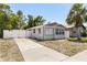 A single story grey home with a large driveway and white fence at 1465 Pierce St, Clearwater, FL 33755
