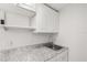 Bright laundry room with white cabinets, granite countertops, and a sink at 1465 Pierce St, Clearwater, FL 33755