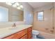 Bathroom with wood vanity, a large mirror, and tiled shower and bath combo at 2006 Sycamore Ln, Plant City, FL 33563