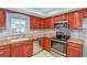Beautiful kitchen with stainless steel appliances, wood cabinets, and tile backsplash at 2006 Sycamore Ln, Plant City, FL 33563