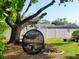 Inviting backyard with mature tree, hanging chair, privacy fence, and space for outdoor enjoyment at 4419 Waltham Dr, Tampa, FL 33634