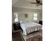 Bedroom featuring a ceiling fan, two windows with shutters, and a bed with a white patterned bedspread at 8252 Tecumseh Cir, Port Charlotte, FL 33981