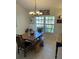Warm dining room boasts a rustic table, a bench, and a stylish chandelier overhead at 8252 Tecumseh Cir, Port Charlotte, FL 33981