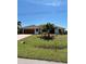 Charming single-story home features lush landscaping, a brown roof, and a two car garage at 8252 Tecumseh Cir, Port Charlotte, FL 33981