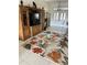 Living room featuring tile floors, floral rug, and large entertainment center at 8252 Tecumseh Cir, Port Charlotte, FL 33981
