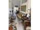 Cozy living room area with wicker furniture, floral rug, and view into the dining area at 8252 Tecumseh Cir, Port Charlotte, FL 33981