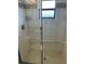 Modern bathroom shower, featuring tiled walls, a glass door, and an overhead shower head at 8252 Tecumseh Cir, Port Charlotte, FL 33981