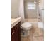 Bathroom featuring a toilet and tub, complemented by neutral tile and fixtures at 9235 Richwood Ln, Port Richey, FL 34668
