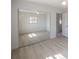Bright bedroom showcases a mirrored closet door and light wood-look flooring at 9235 Richwood Ln, Port Richey, FL 34668