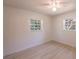 Cozy bedroom featuring wood-look flooring, ceiling fan, and two windows at 9235 Richwood Ln, Port Richey, FL 34668