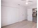 Bedroom features all white paint, a ceiling fan, and multiple closets at 9235 Richwood Ln, Port Richey, FL 34668