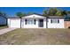 Charming single-story home with a well-manicured lawn and a classic white facade at 9235 Richwood Ln, Port Richey, FL 34668