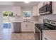 The kitchen features stainless steel appliances and white cabinets at 9235 Richwood Ln, Port Richey, FL 34668