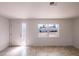 Well-lit living room boasts tile flooring, white walls and trim, and a window at 9235 Richwood Ln, Port Richey, FL 34668