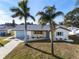 Aerial view of a house with a well-kept lawn, palm trees, and blue accents at 105 12Th Sw St, Ruskin, FL 33570