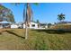 A wide shot of the backyard featuring green space and landscaping at 105 12Th Sw St, Ruskin, FL 33570