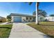 Charming home with a blue garage door, manicured lawn, and lush landscaping at 105 12Th Sw St, Ruskin, FL 33570