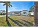 Well-kept home showcasing a manicured lawn, palm trees, and a blue front door at 105 12Th Sw St, Ruskin, FL 33570