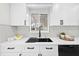 Modern kitchen sink with white cabinets, quartz countertops, and stainless steel appliances at 105 12Th Sw St, Ruskin, FL 33570