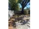 Backyard with a mix of concrete and natural groundcover next to a high privacy fence at 1317 W Alicia Ave, Tampa, FL 33604