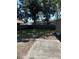 Backyard with a grassy area, large shade trees, and wooden privacy fence at 1317 W Alicia Ave, Tampa, FL 33604