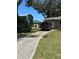 Long driveway leading to a one-car garage, with ample space for parking and a green lawn at 1317 W Alicia Ave, Tampa, FL 33604
