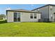 Spacious backyard featuring lush green grass, sliding glass doors, and privacy fencing at 14005 Crutchfield Ct, Parrish, FL 34219