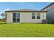 This backyard features green grass, a sliding glass door and windows to let light in at 14005 Crutchfield Ct, Parrish, FL 34219