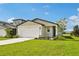 Charming single-story home features a manicured lawn and a two-car garage, complemented by blue skies at 14005 Crutchfield Ct, Parrish, FL 34219