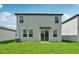 Exterior backyard view showcasing sliding glass doors and well-maintained lawn at 14076 Crutchfield Ct, Parrish, FL 34219