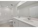 Elegant bathroom featuring double sinks, a large mirror, a pristine white bathtub, and white tiled walls at 14076 Crutchfield Ct, Parrish, FL 34219