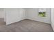 The bedroom features neutral walls, carpet, a window with green views, and a closet for storage solutions at 14076 Crutchfield Ct, Parrish, FL 34219