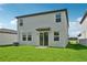 Two-story home with gray siding, a well-maintained lawn, and a sliding glass door leading to the backyard at 14076 Crutchfield Ct, Parrish, FL 34219