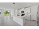 Bright open kitchen with a center island, stainless appliances and sliding glass doors leading to the backyard at 14076 Crutchfield Ct, Parrish, FL 34219