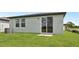 Backyard featuring a sliding glass door leading to the patio and lush green lawn at 14115 Crutchfield Ct, Parrish, FL 34219