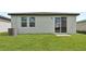 Backyard featuring a sliding glass door, green grass, and an AC unit at 14115 Crutchfield Ct, Parrish, FL 34219