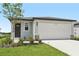 Charming single-Gathering home featuring a two-car garage, landscaped yard, and a covered entry at 14115 Crutchfield Ct, Parrish, FL 34219