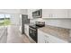 Modern kitchen featuring stainless steel appliances, white cabinetry, and stone countertops at 14115 Crutchfield Ct, Parrish, FL 34219