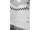 White tiled bathroom with a shower and tub combination, featuring a black and white accent at 2411 W Horatio St # 537, Tampa, FL 33609