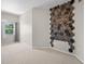 Bedroom with a statement wall, neutral carpet, and a window bringing in natural light at 2411 W Horatio St # 537, Tampa, FL 33609