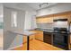 A compact kitchen featuring wood cabinets, black appliances, and a convenient breakfast bar at 2411 W Horatio St # 537, Tampa, FL 33609
