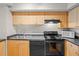 A well-lit kitchen with wood cabinets and modern black appliances, including a microwave and oven at 2411 W Horatio St # 537, Tampa, FL 33609