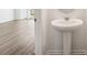 This home has a pristine pedestal sink in the half bath with wood-look floors and sleek fixtures at 4249 Banjo Lake Rd, Land O Lakes, FL 34639