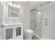 Bathroom featuring a glass enclosed shower, white cabinets and vinyl floors at 4604 Hunts Ave, Plant City, FL 33566