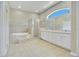 Primary bathroom featuring a large tub, walk-in shower, and dual sinks at 212 Citrus Landing Dr, Plant City, FL 33563