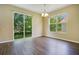 Dining area with dark wood flooring, chandelier, and sliding glass doors to backyard at 212 Citrus Landing Dr, Plant City, FL 33563